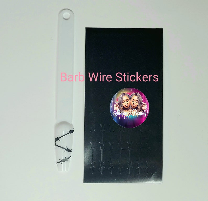 Puede incluir: Una hoja de papel adhesivo negro con varios dise&ntilde;os de alambre de p&uacute;as negro. La hoja tambi&eacute;n incluye una pegatina redonda con un dise&ntilde;o colorido que presenta a dos mujeres y el texto "Shasha Beauty". El texto "Barb Wire Stickers" est&aacute; impreso en rosa en la hoja.