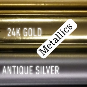 Op de afbeelding: Close-up van metallic afwerkingen, waaronder Antiek Goud, 24K Goud, Antiek Zilver en Chroom. Een wit label met het woord "Metallics" is ook zichtbaar. De afbeelding toont een verscheidenheid aan glanzende, reflecterende oppervlakken.