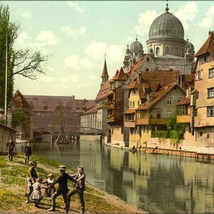 Puede incluir: Una postal antigua que representa una escena de canal en Nuremberg, Alemania. La postal muestra una vista del río Pegnitz, con varios edificios que bordean las orillas. Los edificios son una mezcla de arquitectura alemana tradicional, incluida una iglesia con una cúpula y una torre. La postal está en color y muestra la escena bajo una luz pintoresca.
