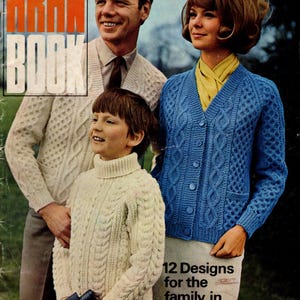 May include: Vintage magazine cover featuring a family wearing Aran knit sweaters and cardigans. The cover has the text "PATONS ARAN BOOK" in orange and white. The family is smiling, and the woman is wearing a blue cardigan. The text "12 Designs for the family in Capstan" is also visible.