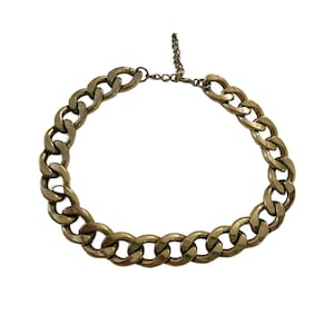 May include: A gold-toned chain necklace with large, interlocking links. The necklace has a classic curb chain design and a lobster clasp closure. The chain is made of metal and has a shiny finish. The necklace is a statement piece.