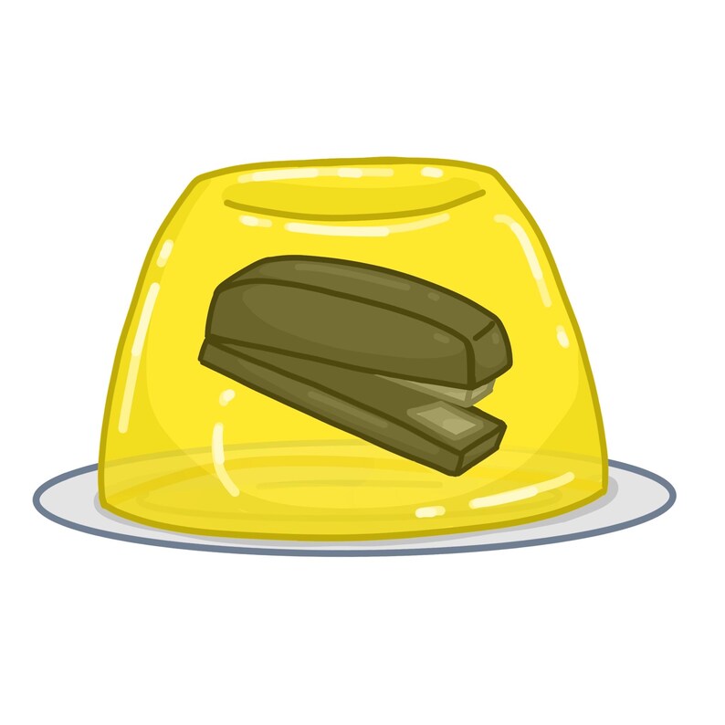 May include: A yellow gelatin dessert with a brown stapler inside. The dessert is on a white plate.