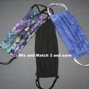 May include: Three face masks, one black, one blue with a white pattern, and one purple with a green and pink pattern. The text "Mix and Match 3 and save" is visible in the image.
