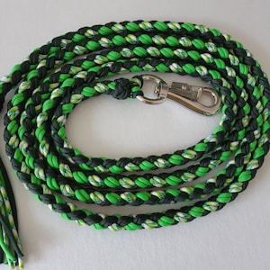 May include: A green and black braided dog lead with a silver clip. The lead has a braided tassel at the end.