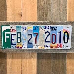 May include: A wooden sign with a date made from license plates. The date is February 27, 2010.