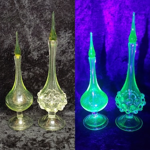 Può includere: Due bottiglie di vetro vintage con superfici testurizzate e tappi in vetro verde. Le bottiglie sono trasparenti e hanno una tinta gialla. Le bottiglie sono mostrate sia in luce normale che in luce UV.