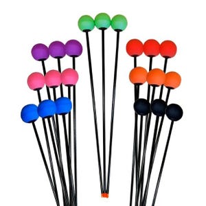 May include: A collection of juggling props featuring colorful spheres atop black rods. The spheres come in various colors, including green, red, orange, pink, purple, blue, and black. The props are designed for juggling and performance.