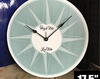 May include: A 17.5 inch round clock with a light blue face and white center. The clock has black hands and a starburst design. The center of the clock has the words "High Tide" and "Low Tide" written on it.