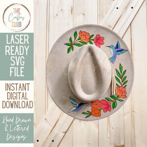 May include: A light gray fedora hat with a floral and hummingbird design. The hat features hand-drawn flowers in shades of orange and pink, with green leaves and blue hummingbirds. The text "LASER READY SVG FILE INSTANT DIGITAL DOWNLOAD" is visible.