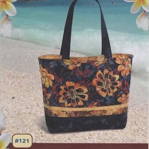 May include: A black tote bag with a floral print and 16 pockets. The bag is labeled "Tuscany Tote" and is described as "Fat Quarter Friendly".