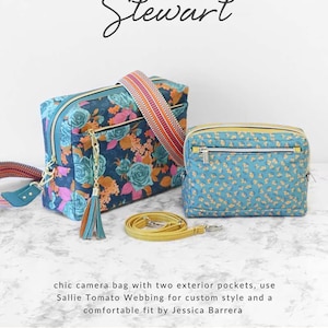 May include: Two camera bags with floral patterns and a yellow strap are displayed. One bag has a navy blue background with orange and pink flowers, while the other has a light blue background with yellow flowers. The bags are part of the "Stewart" collection.