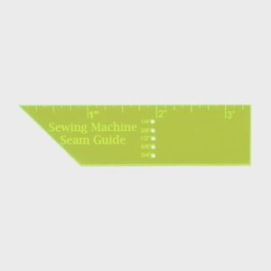 May include: A lime green sewing machine seam guide with inch measurements. The guide has the text "Sewing Machine Seam Guide" and markings for 1/4", 3/8", 1/2", 5/8", and 3/4" seam allowances. The guide is angled on one end.