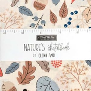 Puede incluir: Una muestra de tela con fondo crema y un patrón de hojas de roble marrones, hojas azules, bellotas y bayas rojas. Una banda de papel blanca en el centro muestra el texto "MODA FABRICS+SUPPLIES NATURE'S SKETCHBOOK BY ELENA AMO" y una regla.