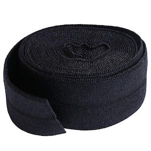 Può includere: Un rotolo di elastico nero, un tipo di tessuto utilizzato per cucire e per l'artigianato.