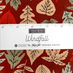 May include: A fabric bundle featuring a dark red background with a pattern of autumn leaves in shades of beige, sage green, and orange. A white paper band across the center displays the text Moda Fabrics, Windfall, and Stephanie Sliwinski.