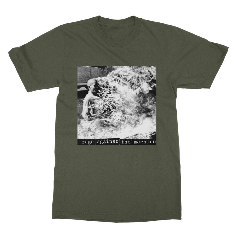 May include: A green t-shirt with a black and white image of a person engulfed in flames. The text "rage against the machine" is printed in black below the image.