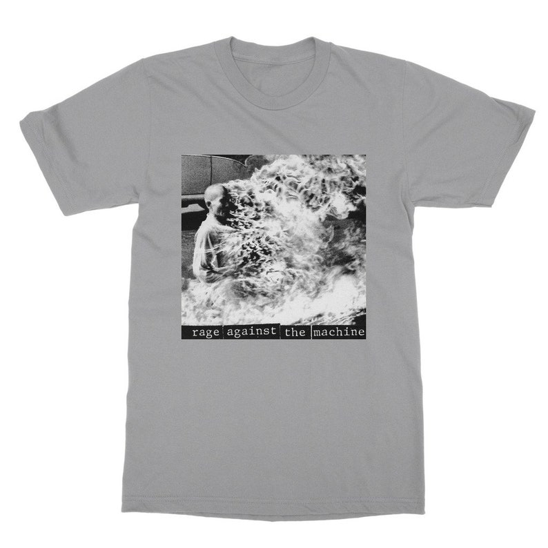 May include: A grey t-shirt with a black and white image of a person engulfed in flames. The text "rage against the machine" is printed below the image.