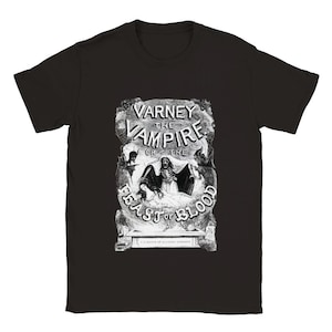 Puede incluir: Camiseta negra con un estampado gráfico blanco de una portada de libro vintage con un vampiro y el texto "Varney the Vampire or the Feast of Blood".