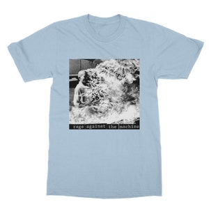 May include: Light blue t-shirt with a black and white image of a person engulfed in flames. The text "rage against the machine" is printed in black below the image.
