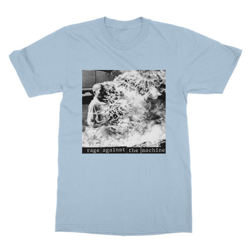 May include: Light blue t-shirt with a black and white image of a person engulfed in flames. The text "rage against the machine" is printed in black below the image.