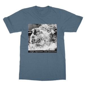 May include: A blue t-shirt with a black and white image of a person engulfed in flames. The text "rage against the machine" is printed below the image.