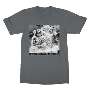May include: A dark gray t-shirt with a black and white image of a person engulfed in flames. The text "rage against the machine" is printed in white below the image.