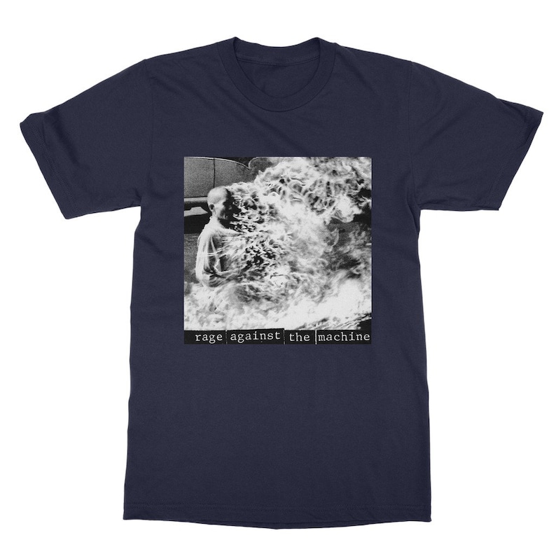 May include: A navy blue t-shirt with a black and white image of a person engulfed in flames. The text "rage against the machine" is printed in white below the image.