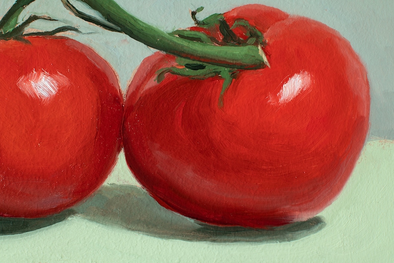 May include: Two red tomatoes on a green surface. The tomatoes are attached to a green vine.