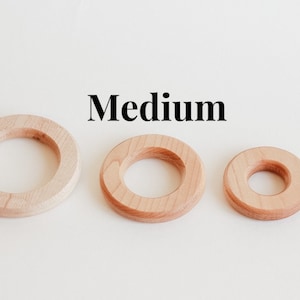 May include: Three wooden rings of different sizes, labelled "Medium". The rings are all made of light-coloured wood and have a smooth finish.
