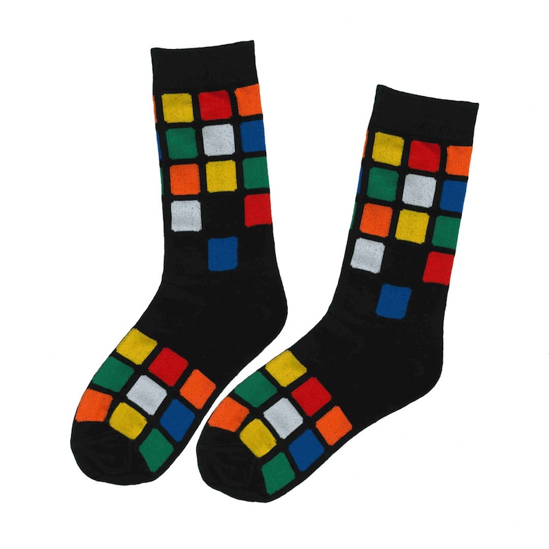 May include: A pair of black socks with a colorful Rubik's Cube pattern on the front. The socks are made of a soft, comfortable material and are perfect for everyday wear.
