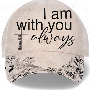 May include: A beige baseball cap with the text "I am with you always" in black script. The brim features a black and white floral and bird design. The text "Matthew 28:20" is printed on the side.