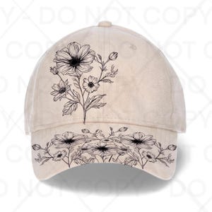 May include: A beige baseball cap with a black floral design. The cap has a curved peak and a rounded crown. The floral design features detailed drawings of flowers and leaves, adding a touch of nature-inspired style.