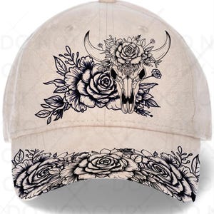 Könnte beinhalten: Eine beige Baseballkappe mit einer schwarzen Strichgrafik eines mit Rosen geschmückten Stierschädels auf der Vorderseite. Der gebogene Schirm ist mit einem durchgehenden schwarzen Strichmuster aus blühenden Rosen und Blättern verziert.
