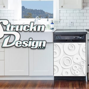 May include: A white dishwasher with a modern, abstract design featuring overlapping circles in shades of grey. The dishwasher is in a kitchen setting with white cabinets and a stainless steel stove.
