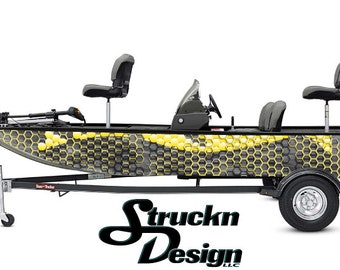 Può includere: Una barca da pesca nera e gialla con un motivo a nido d'ape sul lato. La barca è su un rimorchio con un logo in bianco e nero che dice "Struckn Design LLC".