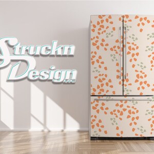 May include: A white refrigerator with a removable, patterned door wrap. The wrap features a repeating pattern of orange and green abstract shapes on a cream background. The text "Struckn Design LLC" is visible on the wall behind the refrigerator.