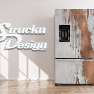 Può includere: Frigorifero in acciaio inossidabile con design personalizzato. Le ante presentano un effetto vernice rame e bianco invecchiato. Il frigorifero ha un erogatore di acqua e ghiaccio, contro un muro bianco.