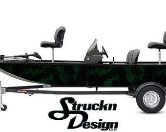 Può includere: Un design di wrap per barca in mimetica nero e verde con una barca nera su un rimorchio. La barca ha un motore fuoribordo Mercury e due sedili da pesca. Il design presenta un motivo ripetitivo di foglie e rami.