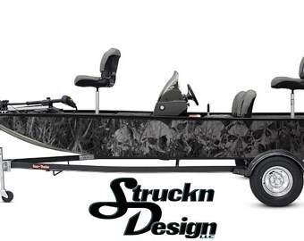 Puede incluir: Un barco de pesca con estampado de camuflaje en blanco y negro en un remolque con un motor fueraborda Mercury. El barco tiene cuatro asientos y un portacañas. El barco está sobre un fondo blanco.