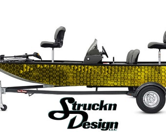 Può includere: Una barca da pesca nera e gialla con un motivo a nido d'ape sul lato. La barca è su un rimorchio con un logo nero e giallo che dice "Struckn Design LLC".