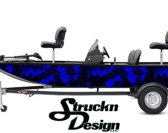 Può includere: Un design di wrap per barca in mimetica nero e blu con un motivo astratto blu e nero. La barca è su un rimorchio con un motore fuoribordo Mercury nero e argento.