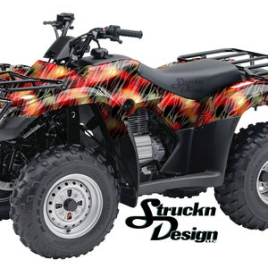 May include: A black ATV with a red, yellow and black flame graphic design. The ATV has a black seat, a black roll cage and black wheels.