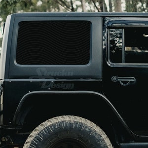 May include: Black Jeep Wrangler with a black window tint and a wavy pattern on the rear window. The Jeep has a black door handle and a black tire.