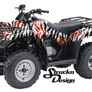 May include: A black, red and white zebra print ATV with a black roll cage and a black seat. The ATV has four large tyres and a black engine.