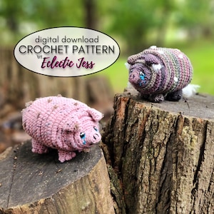 May include: Two crocheted pig plushies with teardrop designs on their faces. The pig on the left is pink with white spots, and the pig on the right is purple with white spots. The pigs are sitting on tree stumps in a woodland setting. The text "digital download CROCHET PATTERN by Eclectic Jess" is displayed above the pigs.