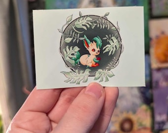Könnte beinhalten: Ein Aufkleber mit einem Cartoon-Eevee mit grünen und orangefarbenen Akzenten, umgeben von grünen Blättern und Ranken. Das Eevee befindet sich in einem Kreis mit schwarzem Hintergrund.