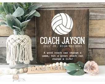 Könnte beinhalten: Ein Holzschild mit einem weißen Volleyball und dem Text "COACH JAYSON 2022 JR. HIGH RAIDERS Ein guter Trainer kann ein Spiel verändern, aber ein großartiger Trainer kann ein Leben verändern!"