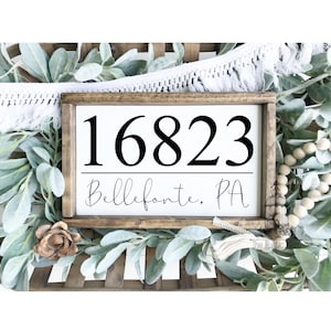 May include: A white wooden sign with black text. The sign reads "16823 Bellefonte, PA".
