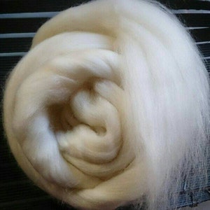 May include: A large quantity of white wool roving, a type of fibre used for spinning yarn or felting.