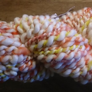Bulky funky Art yarn: alpaca and wool blend, hand spun and hand-dyed. White with shades of yellow, orange, red and pink. 187 grams approx